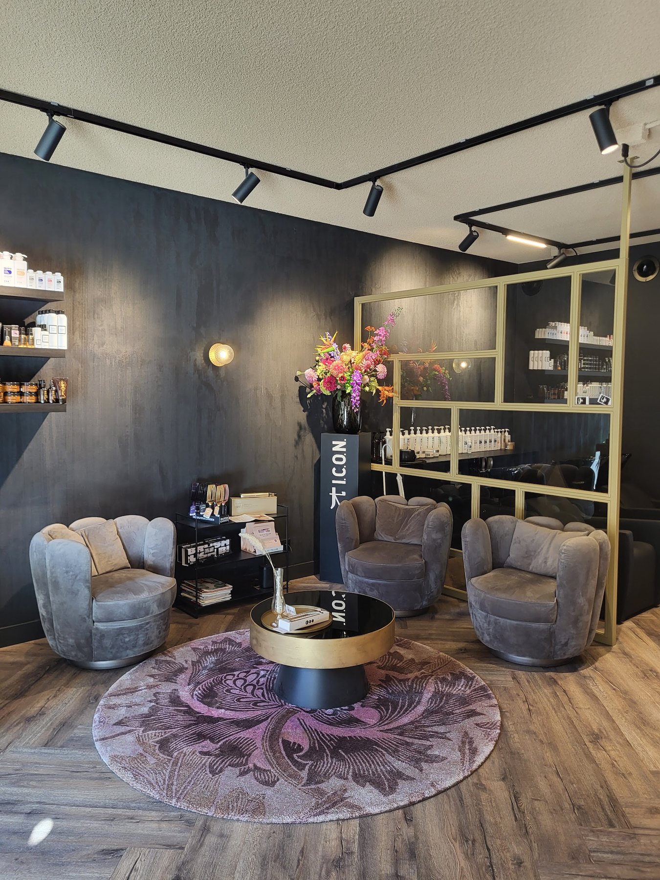 Zithoek met fluwelen stoelen op een rond kleed, gouden wandrek erachter