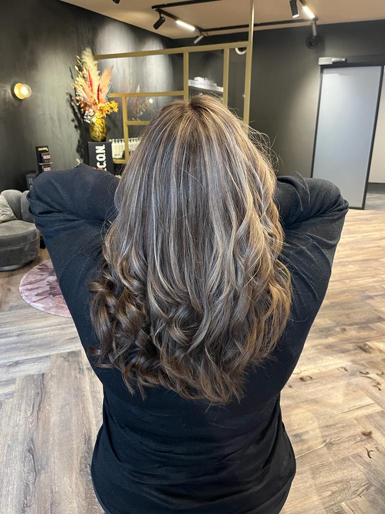 Lang golvend haar met lichte strengen, van achteren gezien in de salon